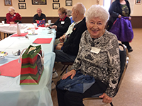 picture of older woman in a group holiday gathering smiling