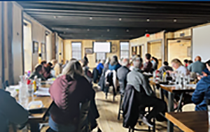 past lenders forum photo of tables full of people in a meeting space